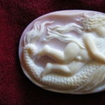 Cupid on a Fish. size 6 x 4.2cm  Sea Shell.
Antique mythology image is carved on a white -
roze colore sea shell.